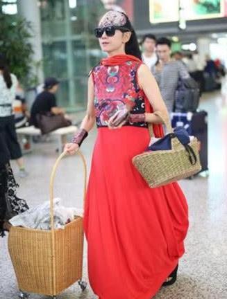 60岁杨丽萍真疯狂,穿20岁的衣服走机场,网友:口罩上的字亮了