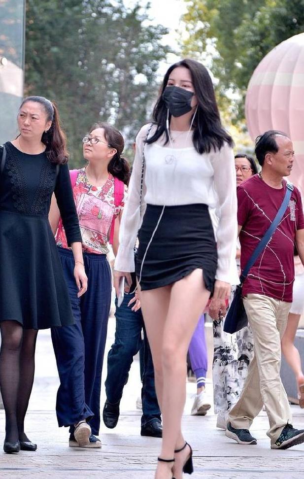 包臀裙很短了，美女还将裙子提的高高的，两个小开叉更显腿长！