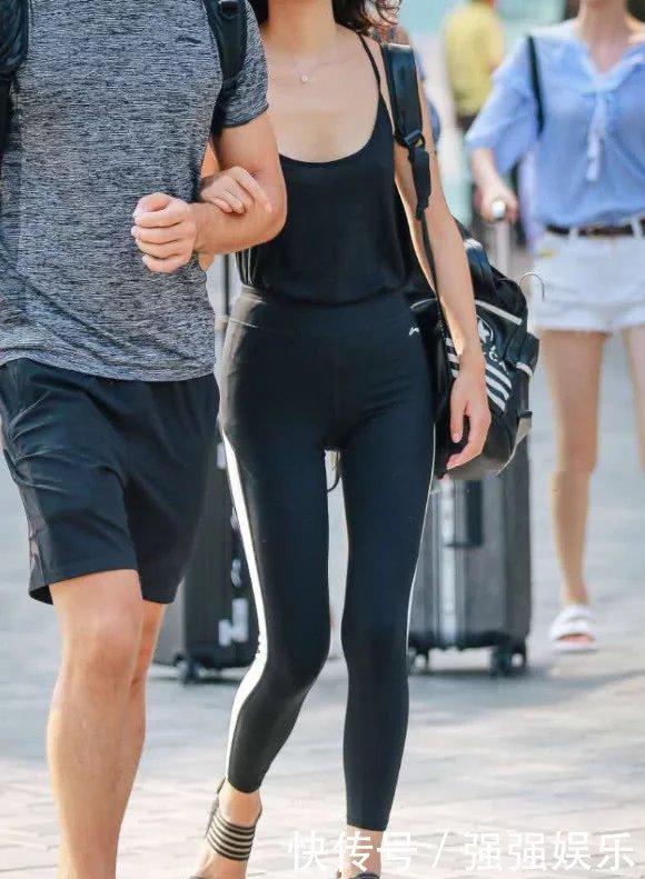 气质小姐姐身穿紧身裤跟男朋友出门,宽松的吊带大低领的设计把小