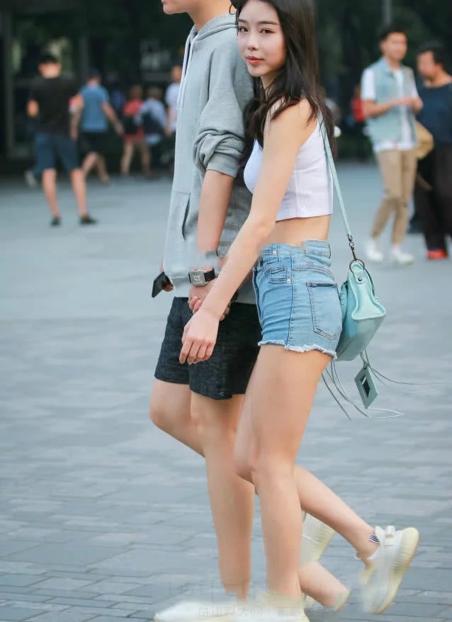 甜美小姐姐露脐装秀出白皙小蛮腰，超短裤裹出浑圆曲线，丸子头俏