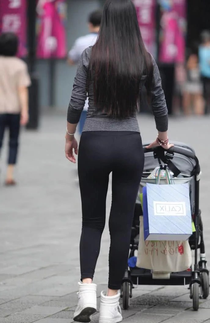 时尚小姐姐带娃逛街，黑色紧身裤裹出曼妙身姿，俏皮的一点很是吸