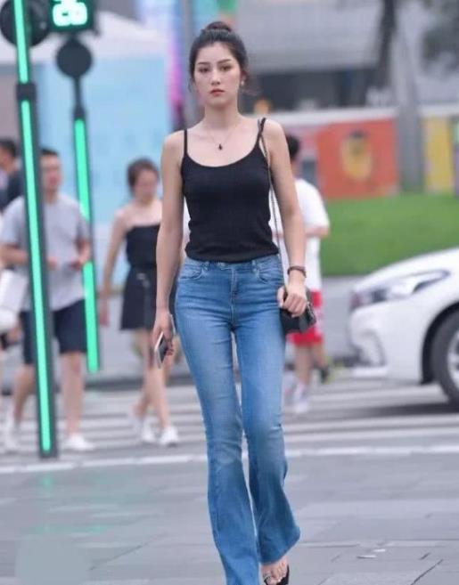 『气质』街拍:身材苗条的小姐姐,身穿黑色背心配牛仔裤,时尚气质十足