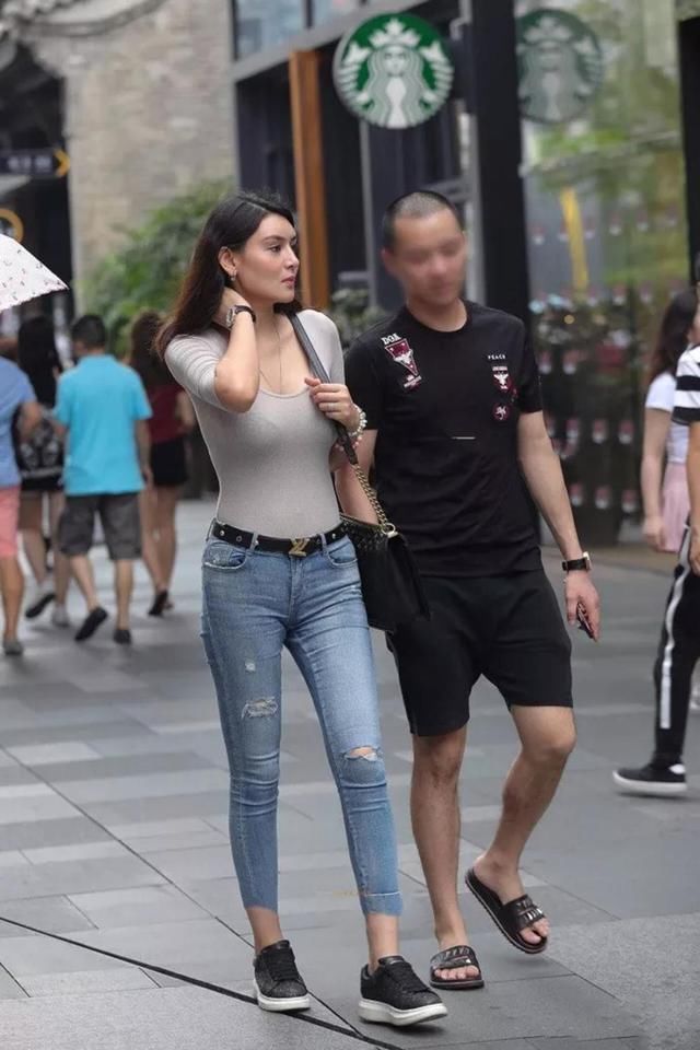 靓丽街拍:丰腴紧身牛仔裤辣妈，傲人身姿很惹眼，看着像混血美女!