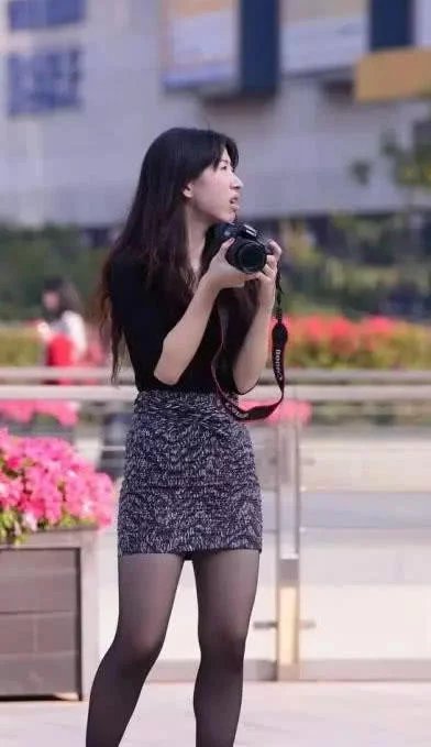 时尚御姐黑色衬衫搭配包臀裙，身材凹凸有致，玩起拍照笑逐颜开可