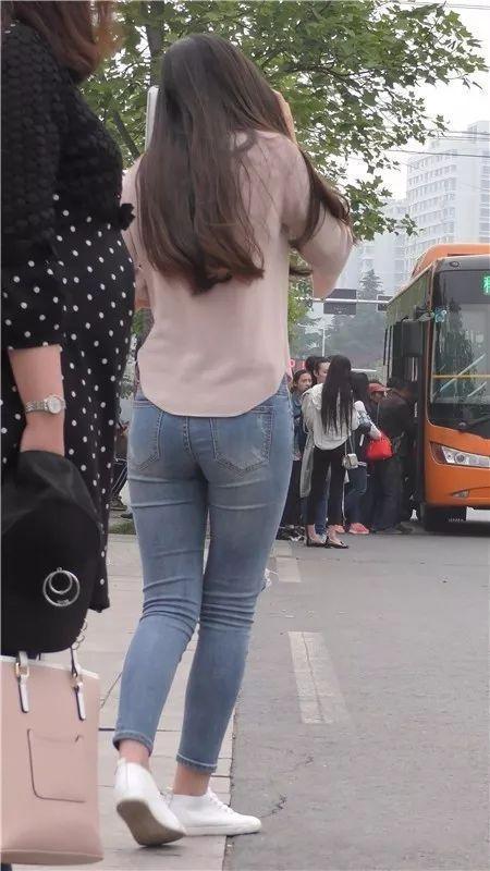街拍美女：在街边等车的紧牛长发俏丽美女