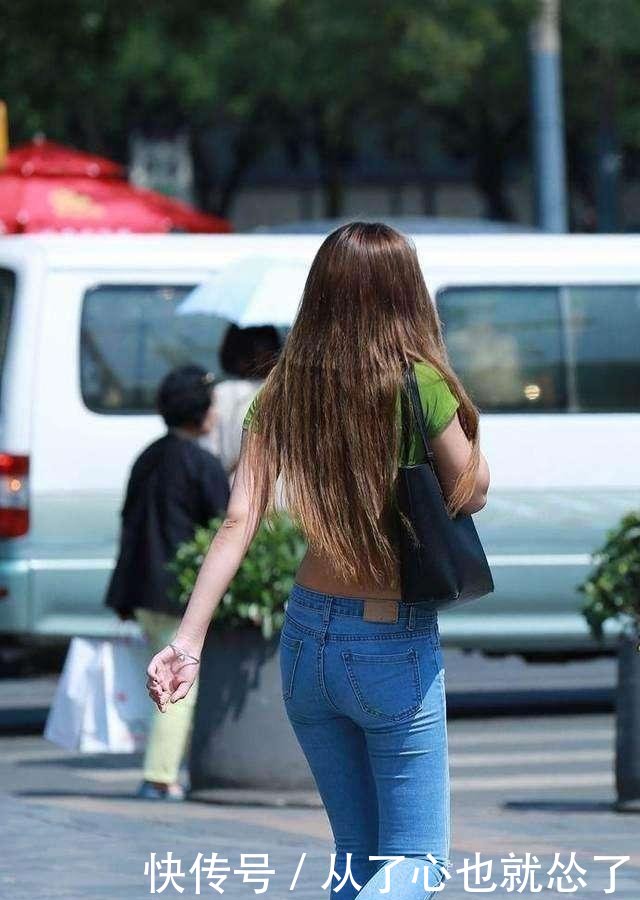 街拍小姐姐绿色紧身T恤搭配紧身牛仔裤，身材高挑玲珑有致
