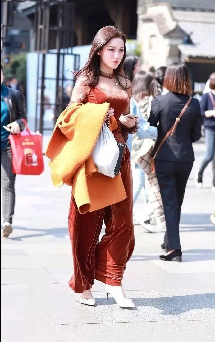 街拍身材饱满的性感美女，上身吊带的样子非常的性感迷人