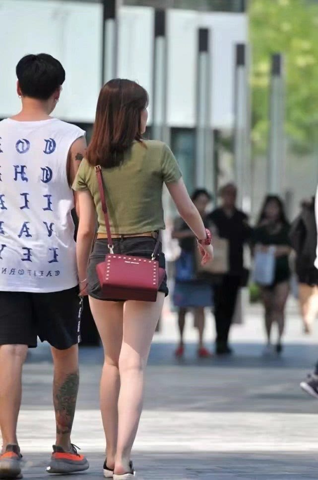 气质小姐姐紧身短裤尽显肥硕大腿，和小十岁男友牵手缠绵不顾路人