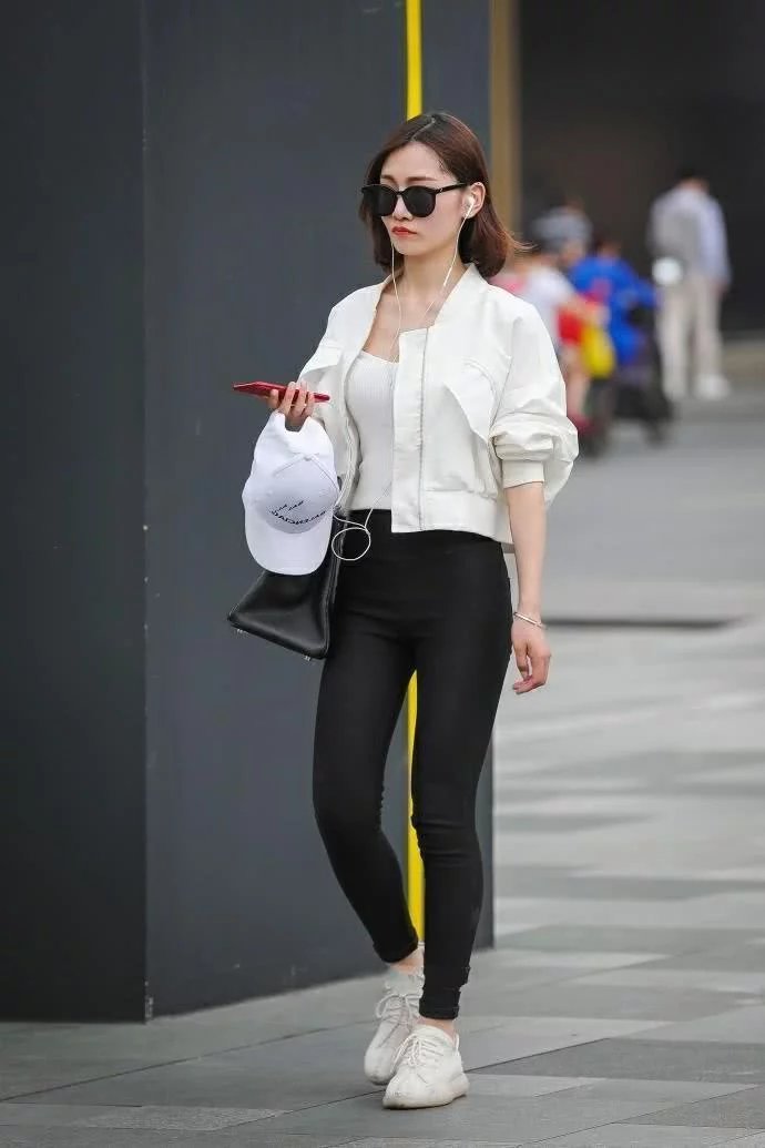 街拍：俏丽小姐姐白色修身背心搭配黑色紧身裤，时尚的穿搭秀出好