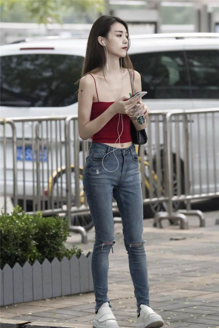 小姐姐选择了一款红色的吊带, 白皙动人的肌肤很是靓丽