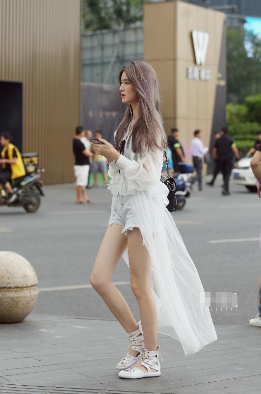 路人街拍，小姐姐身穿一件白色无袖紧身的超短裙，温柔又有女人味