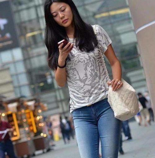  「小姐姐」潮范儿女神来了，街拍：气质温婉的美女，一件黑色外套配紧身牛仔裤，美丽大方迷人