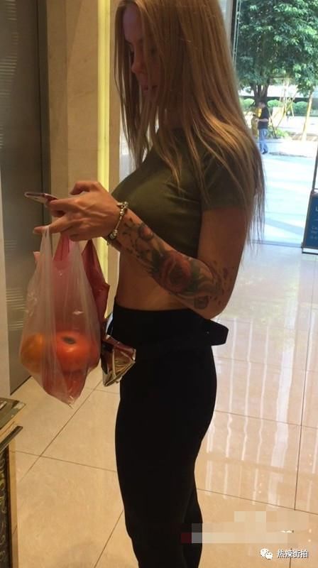 街拍:大街上买水果的外国妞，身材好，时尚感强