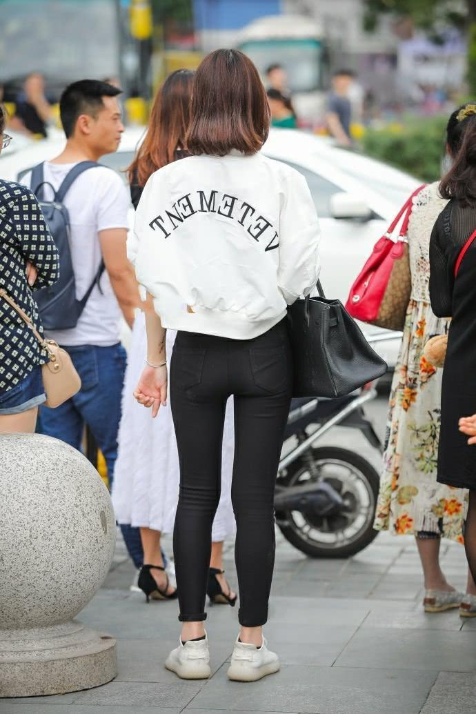 街拍：气质小姐姐紧身裤时尚美腿，一边走一边嘟嘴撩发萌态十足
