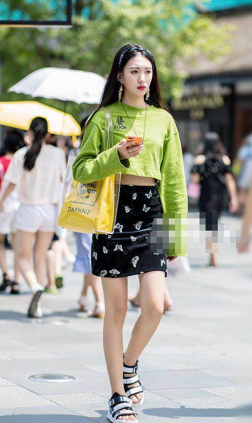 路人街拍，左边小姐姐穿的是黑色吊带的紧身裙，很有活力的穿搭