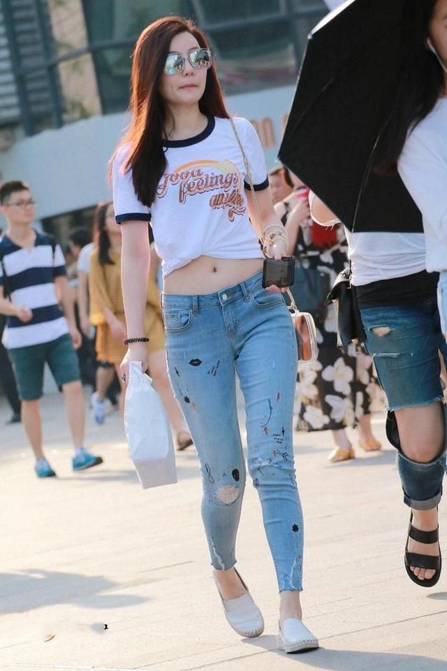 街拍，美丽小姐姐身穿露脐装配牛仔裤，时尚靓丽小蛮腰迷人
