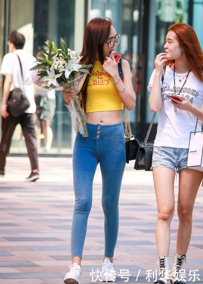 痞子型小姐姐紧身牛仔裤紧紧包裹臀部，勒出性感弧线，走在街头很