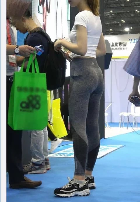 文静小姐姐街头不需要推销，短款上衣搭配灰色紧身裤十分吸睛，可