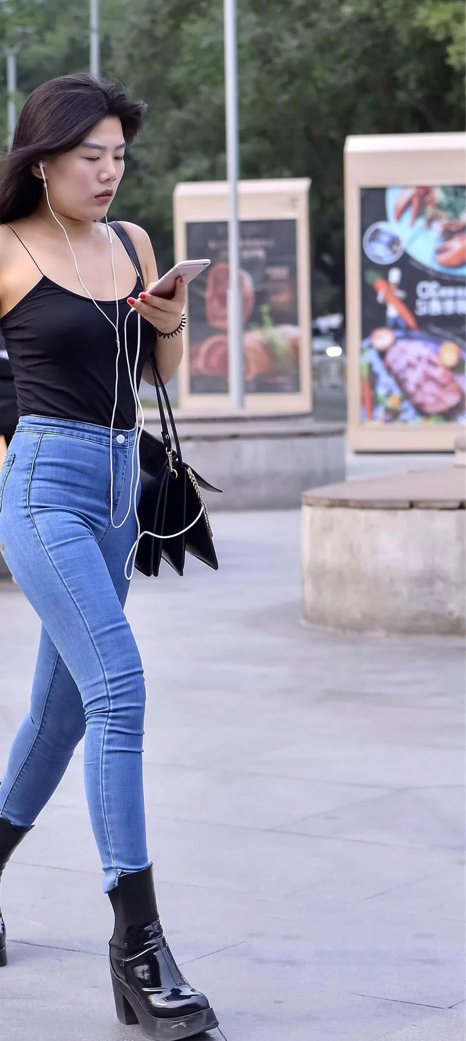 街拍紧身牛仔裤美女，搭配黑色吊带气质性感迷人，背影妖娆迷人