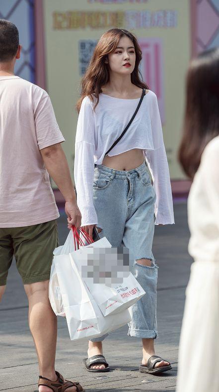 路人街拍，小姐姐身穿浅色破洞牛仔裤，小蛮腰隐隐可现