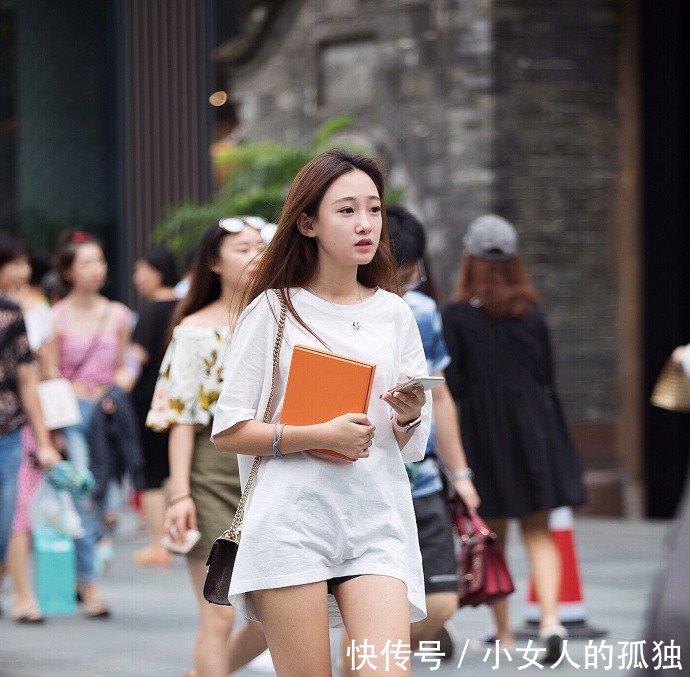 路人街拍小姐姐长T恤秀出性感美腿，精美的面孔有点像明星