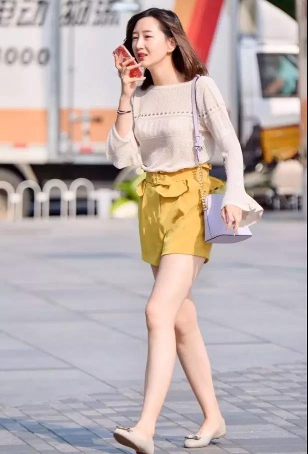 街拍：肤色白皙穿黄色短裤的年轻靓丽性感美女