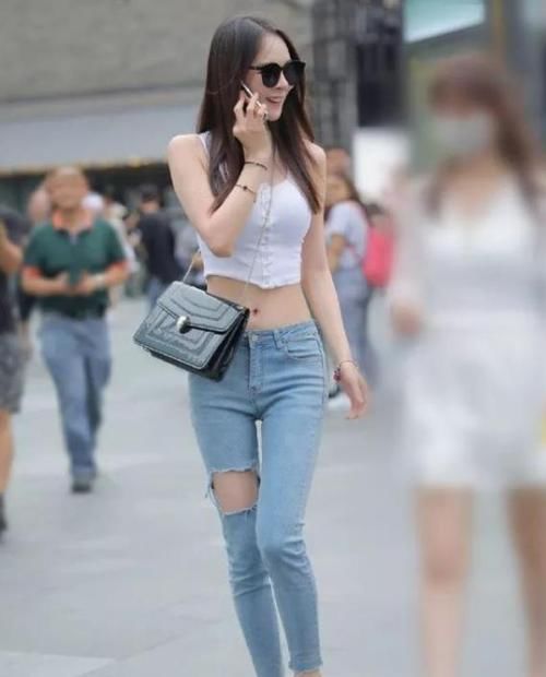 美女：街拍：身材高挑的美女，一件黑色上衣配棕色裤子，时尚活力气质
