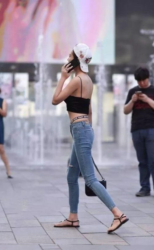 可爱萌妹吊带背心勾勒出凹凸有致的曲线，清爽效果极佳，破洞牛仔