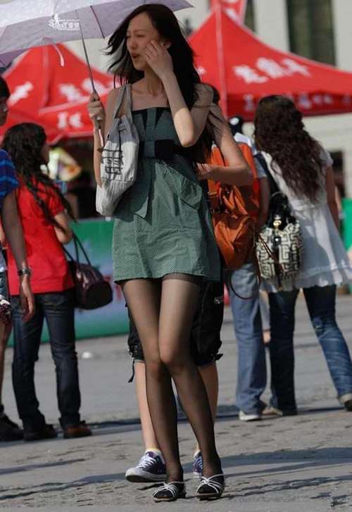 街拍：连衣裙裙下的丝袜大长腿妹子，一双细腿引人注目！