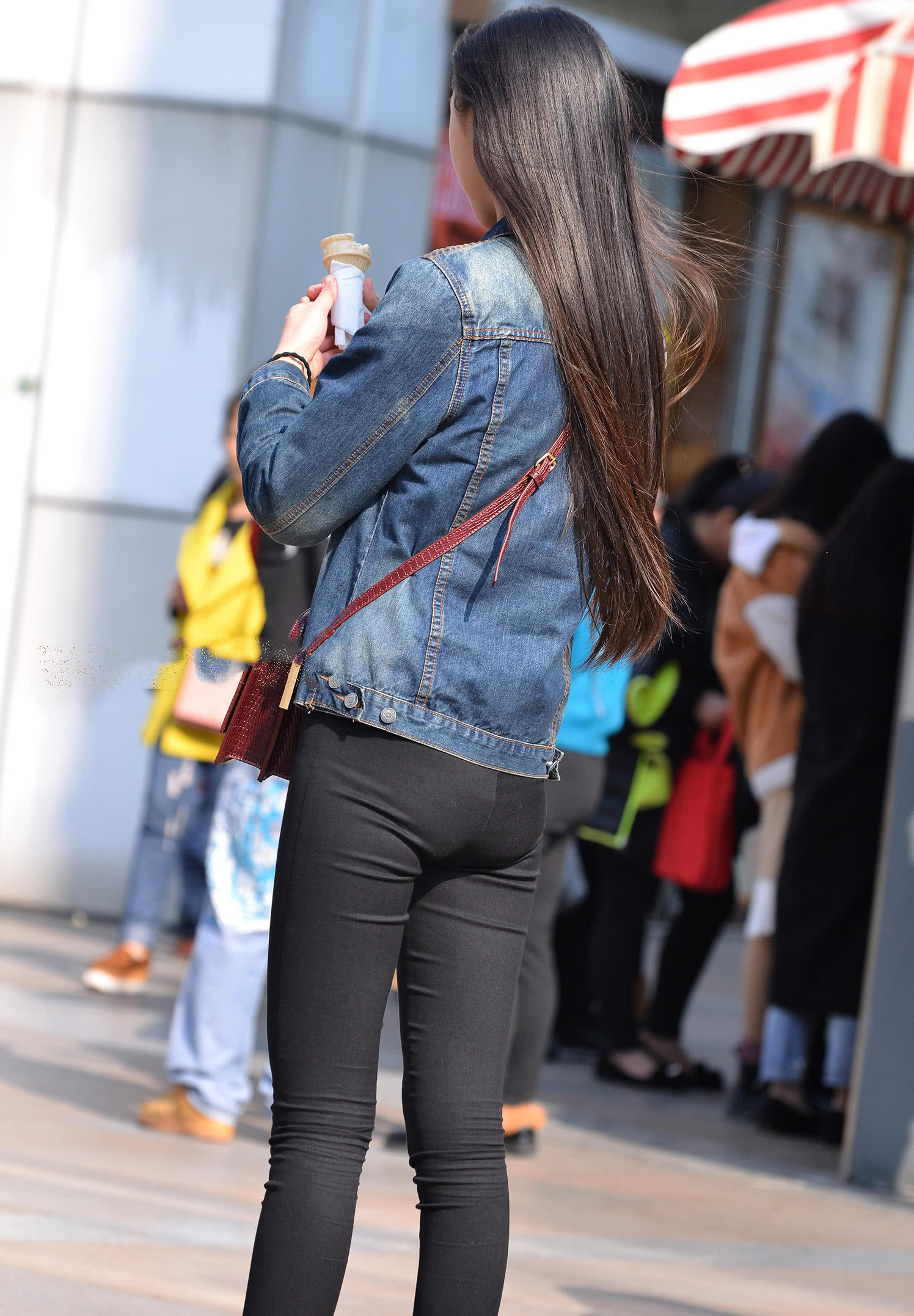 气质小姐姐紧身裤勾勒迷人线条，边走边吃冰淇淋，表情呆萌