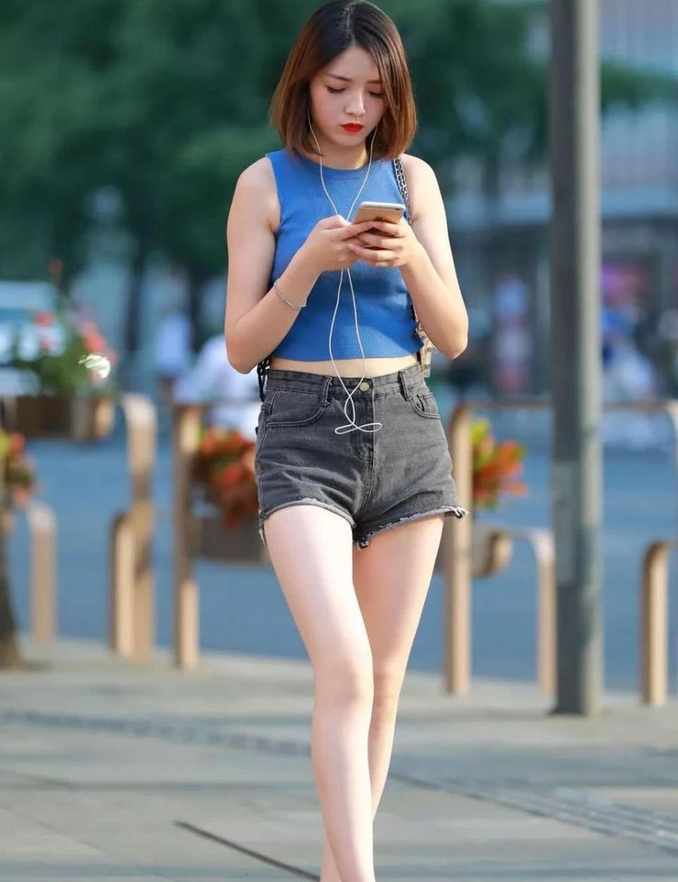 美女身穿超咖啡色的简约小吊带背心，凸显甜美娇柔的女人味