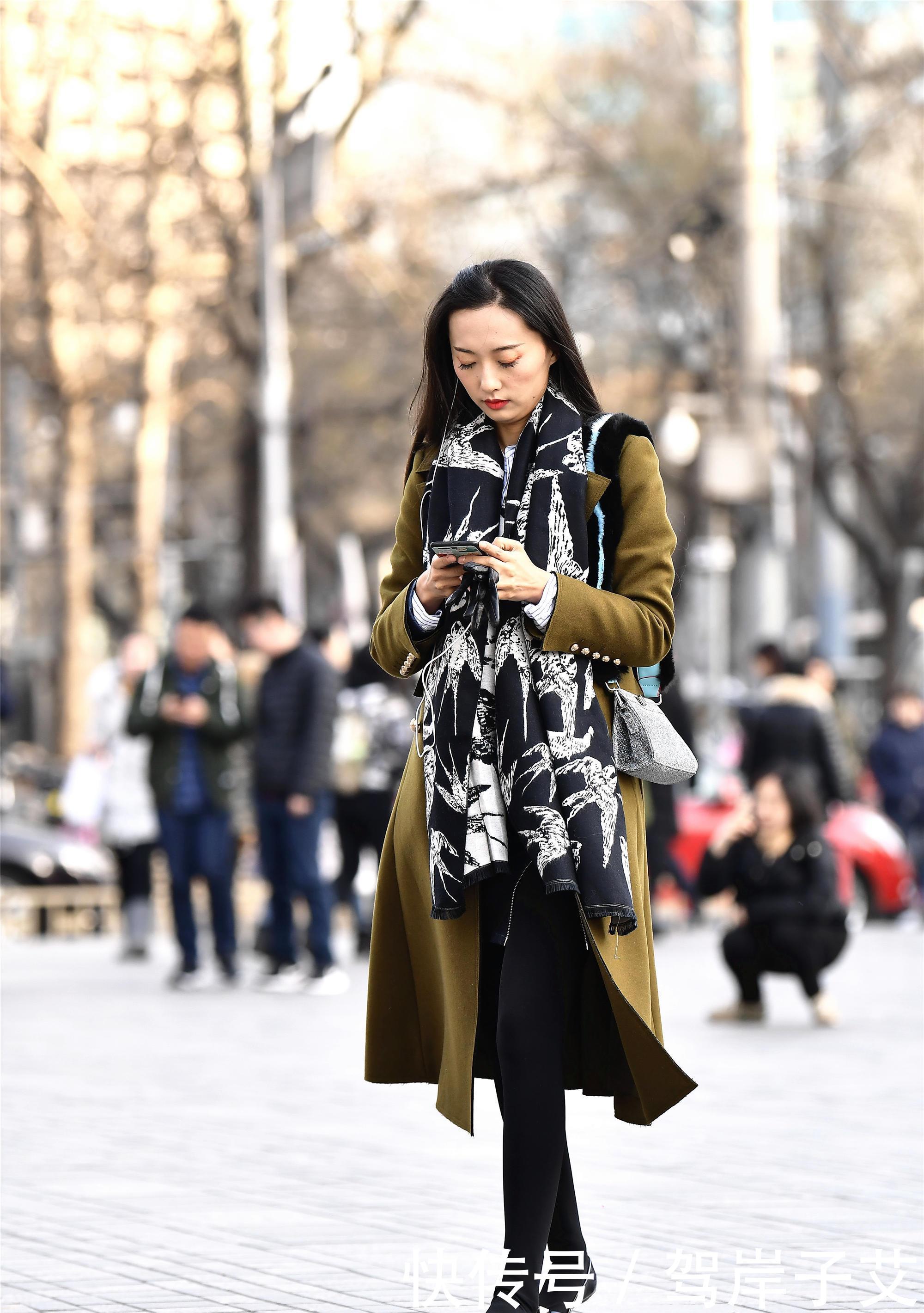 美女■街拍:美女搭配黄绿色的风衣,一条黑色打底裤,身材高挑美丽时尚