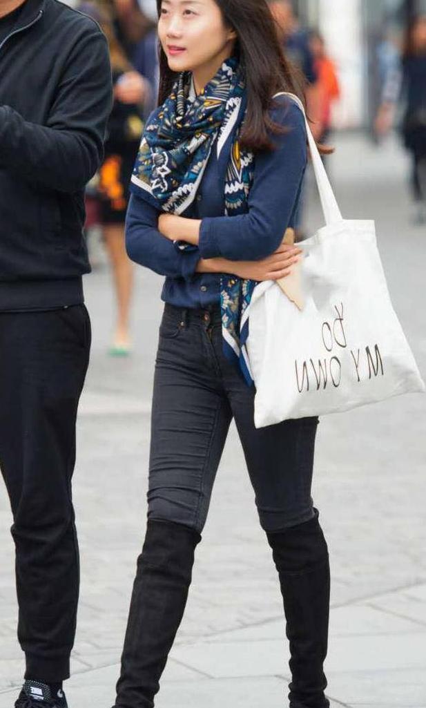 街拍：婴儿肥小姐姐紧身牛仔裤显出了条条弧线，秀出一双修长美腿