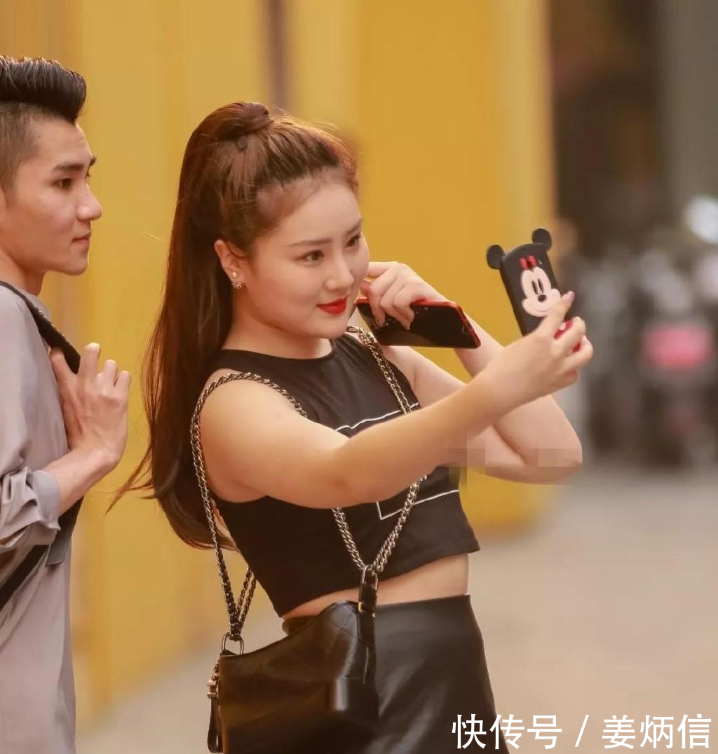 路人街拍，微胖小姐姐穿露脐背心配短裙开心做直播，身材丰满