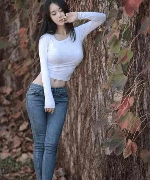 紧身牛仔裤修身显瘦，突出的美女靓丽身材，透露出女性迷人的芬芳