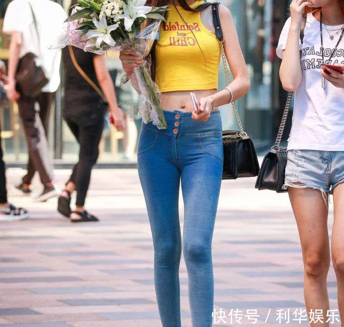 痞子型小姐姐紧身牛仔裤紧紧包裹臀部，勒出性感弧线，走在街头很