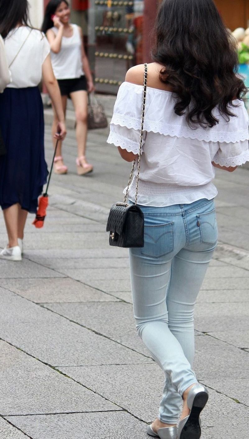 街拍:紧身牛仔裤露肩装美女，纤细的身材引人瞩目