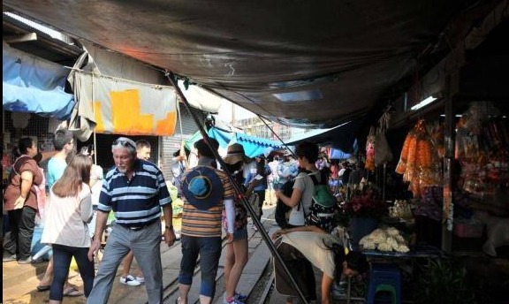 泰国有一条奇葩的火车道，火车横穿菜市场，司机还伸手打招呼！