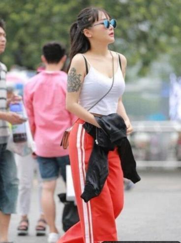  橘色：街拍：浅浅笑容的美女，橘色的外套配上修身长裤，尽显优雅女神魅力