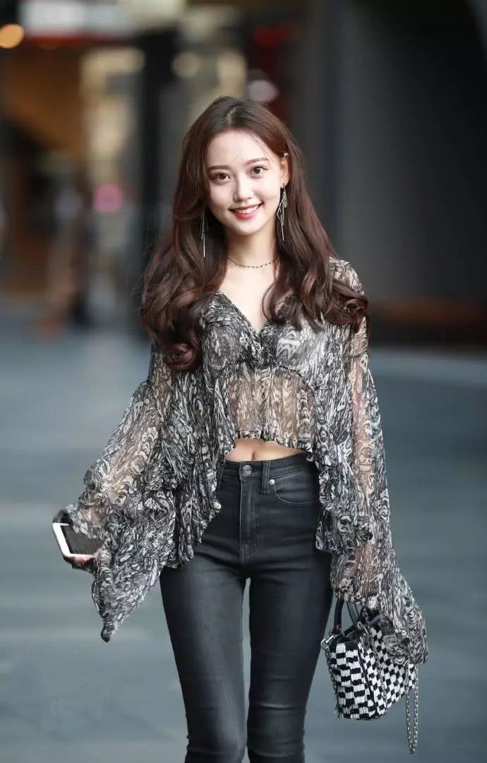 紧身牛仔裤的美女,搭配薄如纱的上衣,美丽又大方,很招人喜欢!