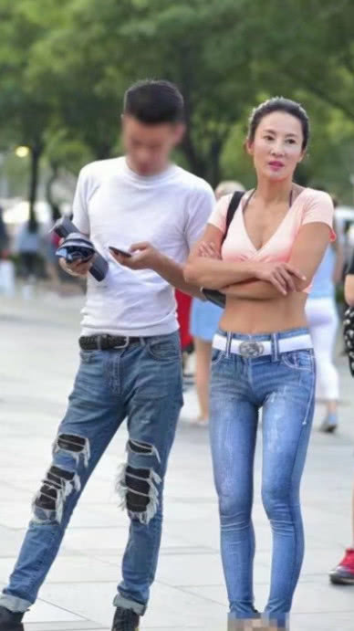 风韵小姐姐穿着牛仔紧身裤尽显玲珑曲线，白色腰带搭配的很亮眼