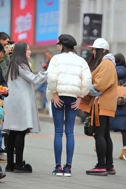 街拍：美女展示自己的曼妙，牛仔裤装点着女神的娇俏