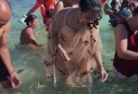 女子穿裙子在海边玩耍，出水的那一刻，旁边的游客眼都直了！