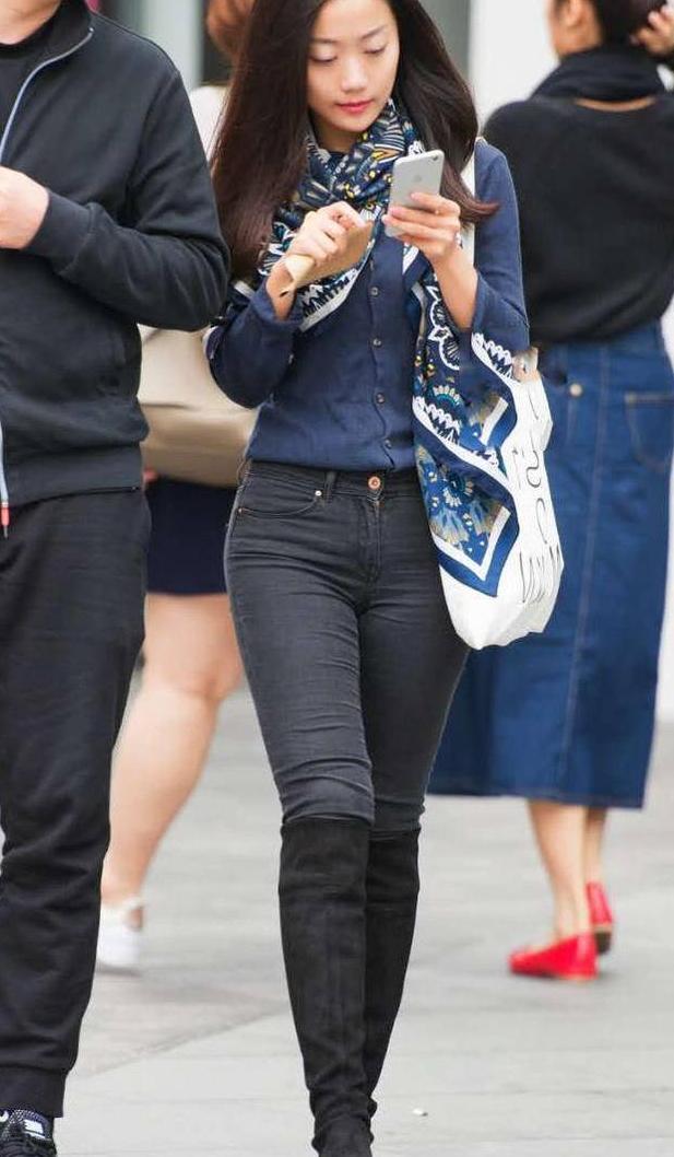 街拍：婴儿肥小姐姐紧身牛仔裤显出了条条弧线，秀出一双修长美腿