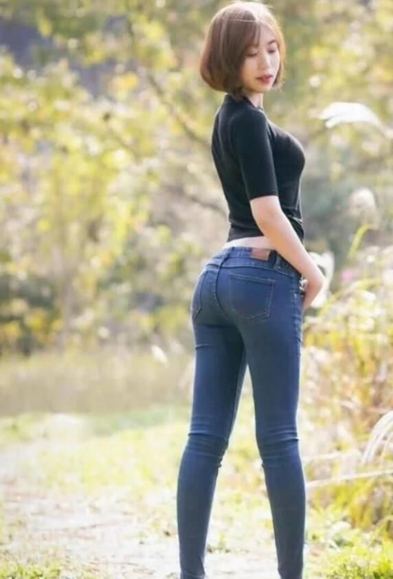 紧身牛仔裤修饰出美女身材曲线感，显现的时尚靓丽又有魅力