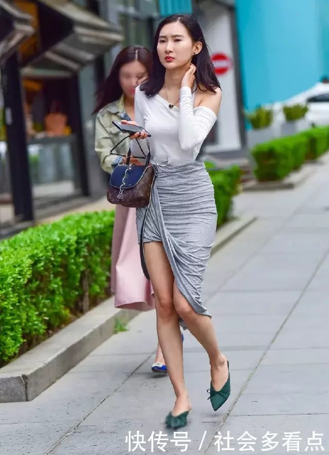 小姐姐太会穿，过膝的长裙将一边的裙角向上翻，是在故意秀美腿吗