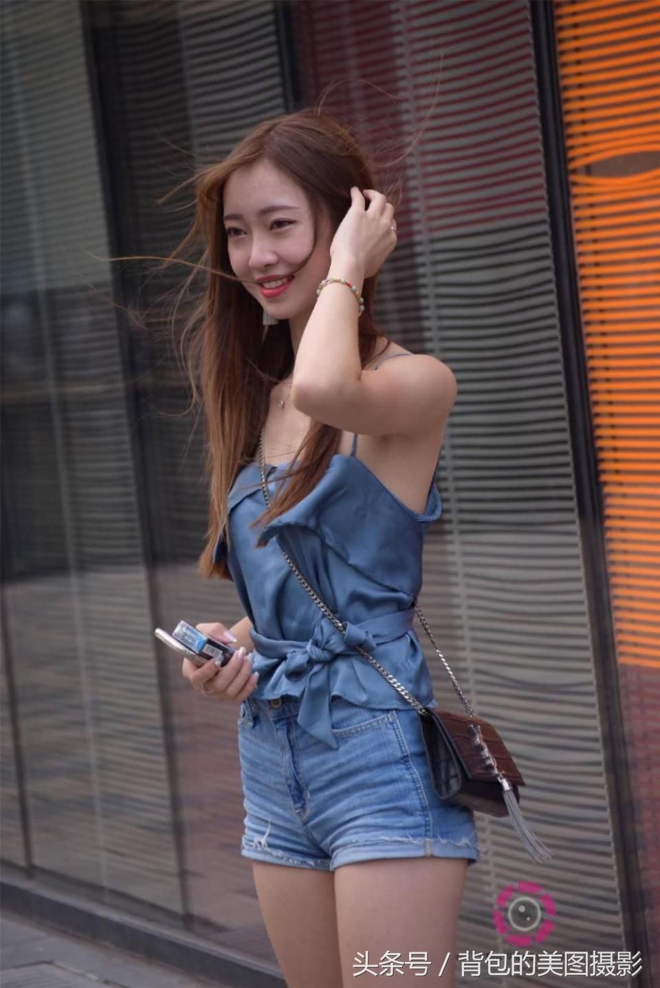 街拍路人，水蓝色吊带搭配牛仔短裤的小姐姐，柔美又帅气