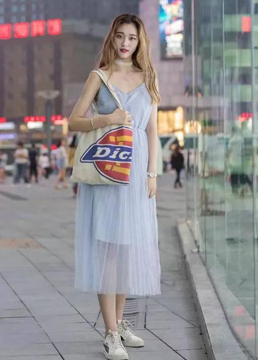 路人街拍，小姐姐上身穿的是一件裸色的吊带背心，非常亮眼