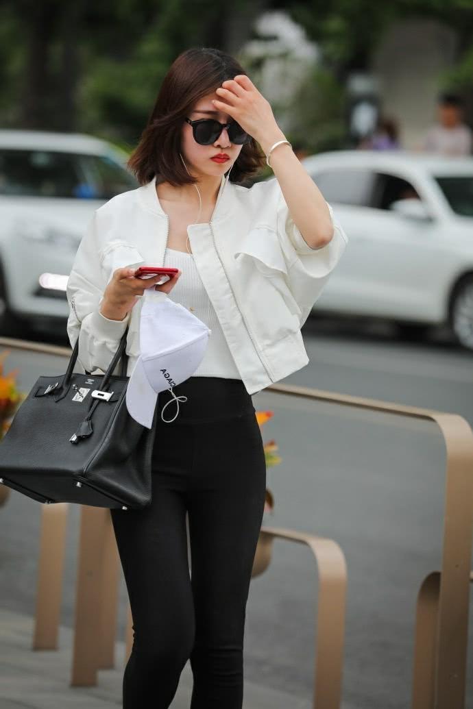 街拍：气质小姐姐紧身裤时尚美腿，一边走一边嘟嘴撩发萌态十足