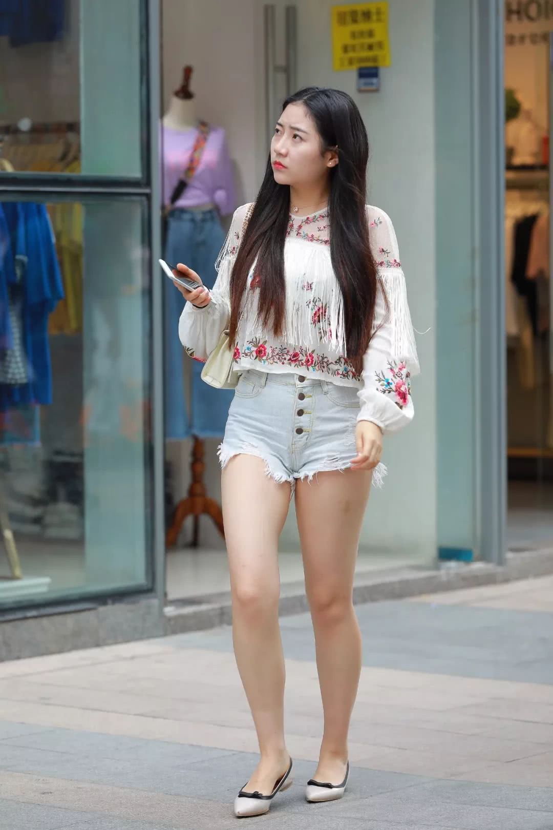 这位小姐姐上衣选择的是一件碎花衫，大腿白皙的肌肤让人尽饱眼福